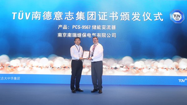 美國(guó)儲(chǔ)能系統(tǒng)技術(shù)委員會(huì)主席、TUVSUD全球風(fēng)險(xiǎn)顧問公司常務(wù)顧問JamesBiggins（右）為南瑞繼保的產(chǎn)品儲(chǔ)能變流器PCS-9567頒發(fā)TUVSUD證書
